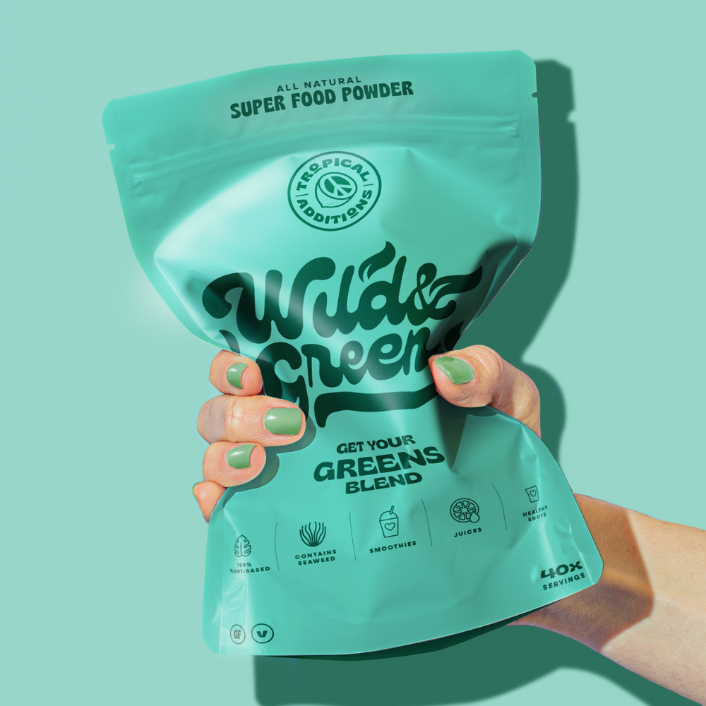tropical additions superfood blends - wild and green daily greens bland packet held by hand